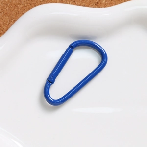 Blue D-ring carabiner spring clip on a ceramic tray for DIY keychain accessories