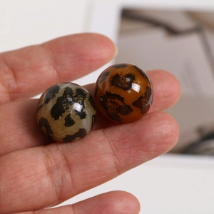 Runde Acryl-Anhänger im Leoparden-Look für DIY-Schmuck und Ohrringe in der Hand