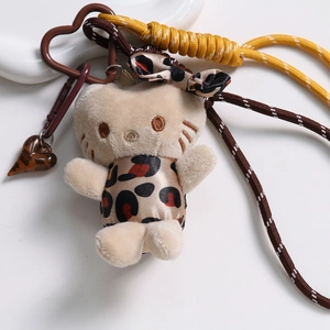 Détail de Hello Kitty en peluche avec robe léopard, cordelette et fermoir en cœur