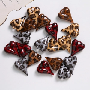 Pendentifs cœur léopard et écossais pour création de bijoux sur fond blanc
