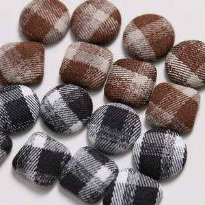 Macro shot of fabric wrapped geometric buttons with classic brown and grey plaid patterns