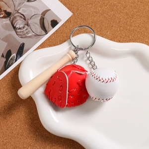 Close-up of mini wooden bat, leather glove and baseball keychain charms in a tray
