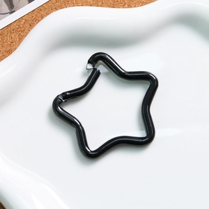 Black star-shaped alloy spring clasp on white plate for DIY keychain accessories