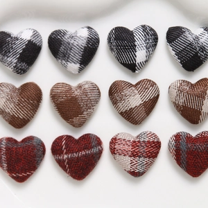 Macro detail of heart-shaped plaid fabric buttons in black, brown and red for DIY crafts