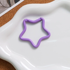 Detailed view of a purple star-shaped spring alloy buckle for keychains on a tray