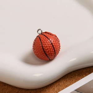Makro-Detail eines strukturierten Basketball-Anhängers mit Metallring auf Keramiktablett