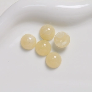 Macro detail of five 12mm amber resin dome beads with natural marble texture patterns