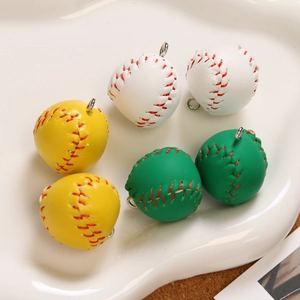 Detailed view of mini baseball keychains with red stitching on a textured white tray