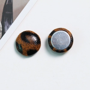 Detailed view of leopard print fabric round buttons with smooth silver metal backing base
