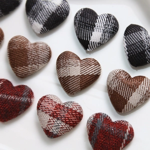 Macro shot of plaid fabric heart buttons for DIY jewelry and hair accessory crafts