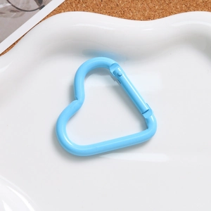 Detail of sky blue heart carabiner clip on white tray for DIY keychain accessories