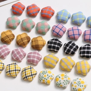 Close-up of colorful checkered and floral fabric star buttons for DIY hair accessories