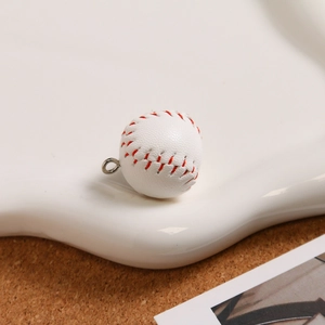 Detailed close-up of a mini baseball keychain with white leather and red stitching details