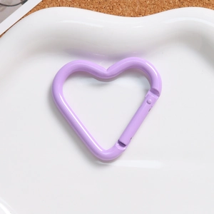 Detailed view of lavender heart-shaped alloy spring clasp on a white ceramic plate
