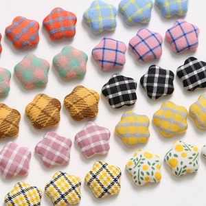 Macro view of colorful plaid and floral fabric star buttons for DIY jewelry making
