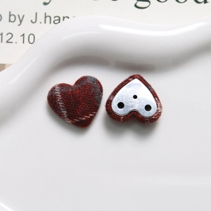 Detailed macro view of heart-shaped plaid fabric buttons with silver metal base for DIY