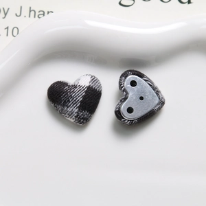 Macro shot of heart-shaped fabric-covered buttons with black and white plaid pattern