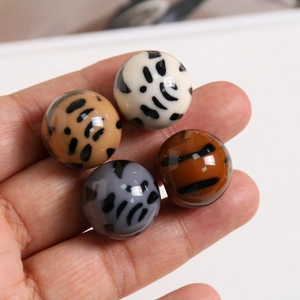 Gros plan de 4 perles en résine motif léopard pour bijoux DIY en différentes couleurs
