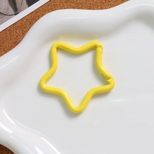 Detail of a star-shaped macaron yellow metal spring buckle for DIY keychains