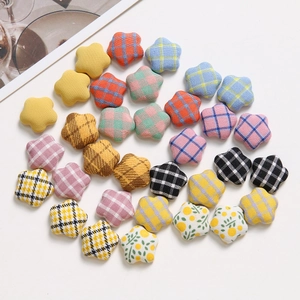 Plush fabric star-shaped accessories with colorful plaid and floral patterns on white background