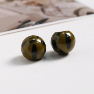 Gros plan sur des perles en résine motif léopard vert olive pour bijoux et accessoires