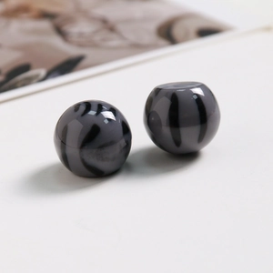 Gros plan de perles en résine gris fumé à rayures de tigre pour bijoux DIY