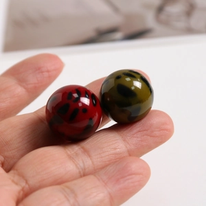 Gros plan de perles en résine à motif léopard rouge et vert olive pour bijoux DIY et coques