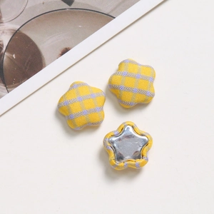 Detailed macro view of yellow plaid fabric star-shaped buttons for DIY hair accessories