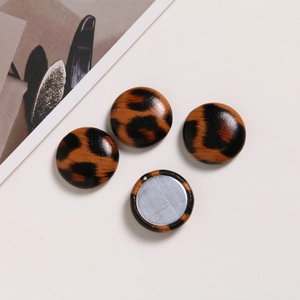 Detailed view of four circular leopard print leather magnetic buttons for DIY crafts