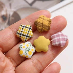 Close-up of assorted star-shaped fabric buttons with plaid and floral patterns for DIY crafts