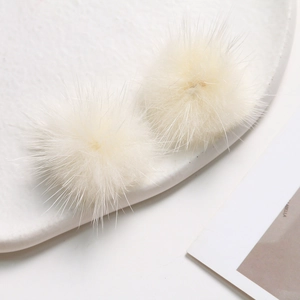 Macro detail of fluffy 3.5cm ivory faux mink fur pom-poms for DIY jewelry and accessories