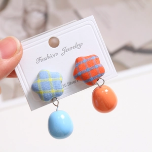 Detail of fabric star stud earrings with plaid pattern and glossy oval drops