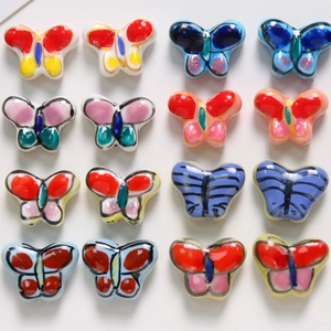 Détail de perles papillon en céramique peintes à la main pour création de bijoux DIY