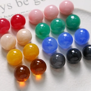 Macro shot of 15.5mm round resin beads with ink-wash texture in various vibrant colors