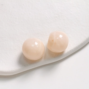 Macro view of 20mm apricot resin round beads with ink smudge texture for DIY jewelry