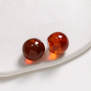 Macro detail of 20mm amber ink-wash resin round beads for DIY jewelry and hair accessories