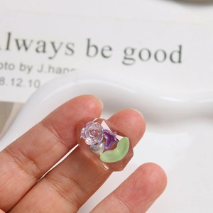 Faceted clear resin pendant with purple rose, silver heart, and green moon inserts