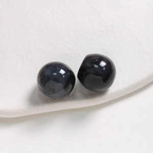 Macro detail of 20mm polished ink-pattern resin beads for jewelry making and DIY crafts