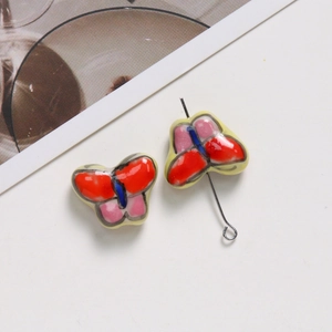 Détail de perles papillon en céramique peintes à la main pour bijoux artisanaux