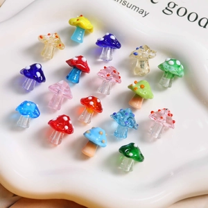 Detailed view of colorful polka dot mushroom glass beads in a white ceramic tray