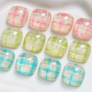 Detail view of square resin charms with colorful grid patterns for DIY crafts