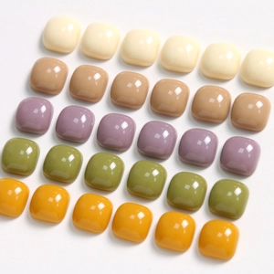 Close-up of 10mm glossy square resin charms in a palette of cream, brown, and green hues