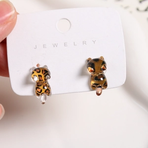 Macro detail of resin leopard print kitten earring studs with polished finish