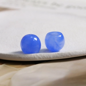 Macro view of 15.5mm blue resin beads with ink-wash texture for DIY jewelry making
