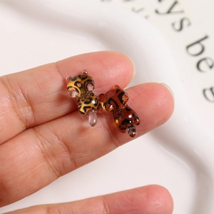 Macro shot of miniature leopard and amber tabby resin kittens for DIY craft accessories