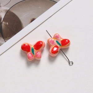 Détail macro d'une perle papillon en céramique colorée pour la création de bijoux DIY