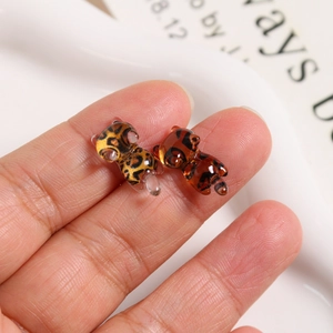 Close-up of mini resin leopard print and amber bear charms for DIY jewelry making