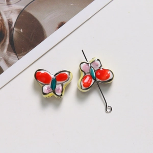 Détails macro de perles papillon en céramique peintes à la main pour bijoux DIY