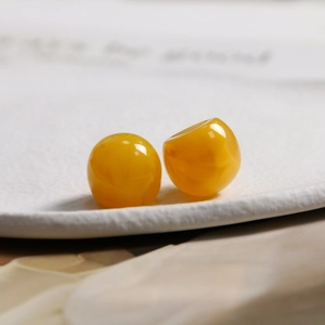 Macro detail of 15.5mm glossy yellow ink-wash resin beads for DIY jewelry and hair accessories