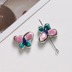 Détail de perles papillon en céramique colorées pour la création de colliers et bracelets